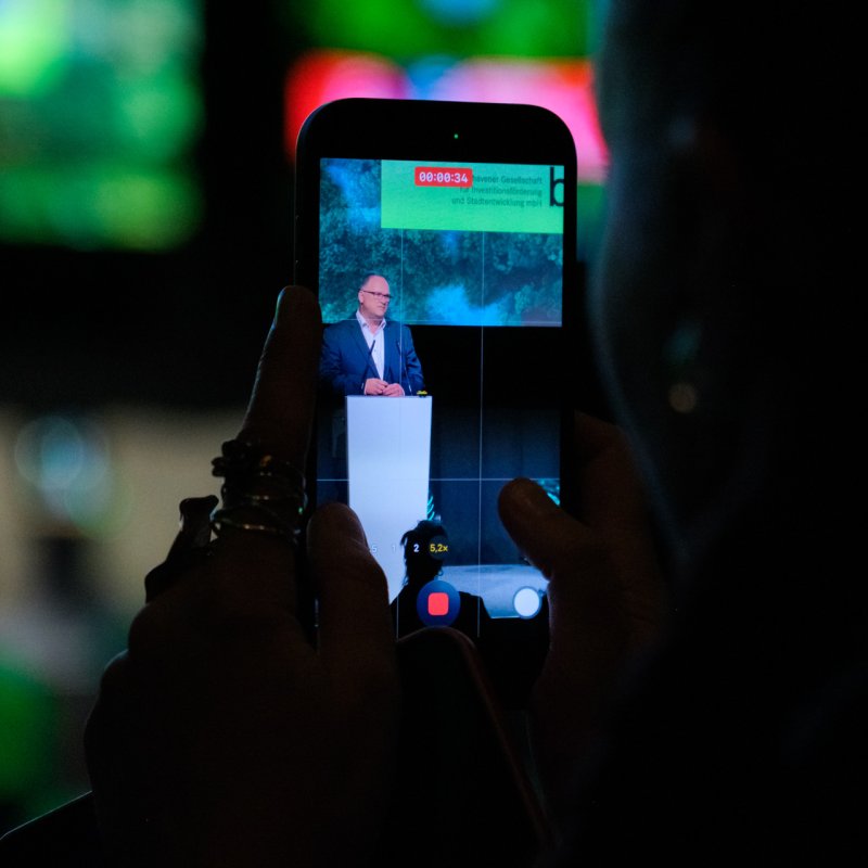 Eröffnungsrede von Björn Fecker durch ein Smartphone fotografiert